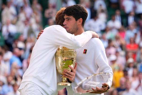 Jannik Sinner of Italy hugs Carlos Alcaraz of Spain after winning the men's singles final match at the Wimbledon Tennis Championships in London, Sunday, July 13, 2025.(AP Photo/Kirsty Wigglesworth)