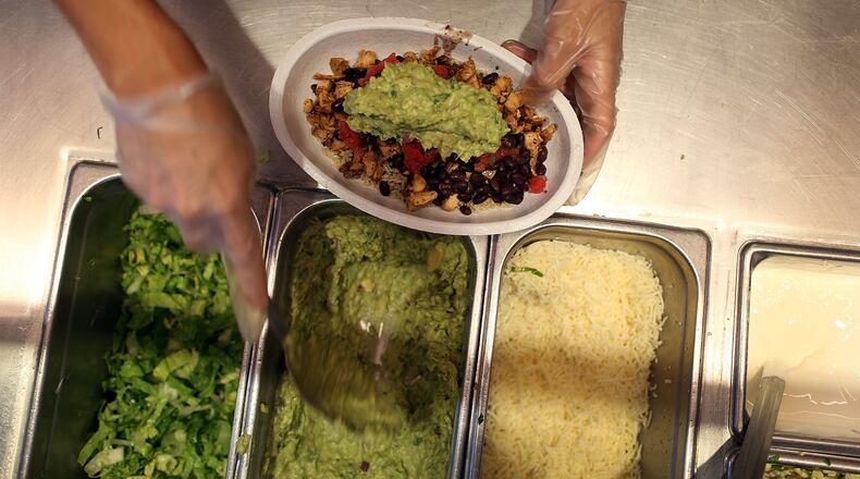 MIAMI, FL - APRIL 27: Chipotle restaurant workers fill orders for customers on the day that the company announced it will only use non-GMO ingredients in its food on April 27, 2015 in Miami, Florida. (Photo by Joe Raedle/Getty Images)