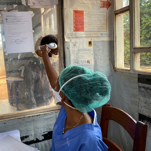 FILE - A medical worker checks a person's temperature at the Matanda Hospital in Butembo, where the first case of Ebola died, in the North Kivu province of Congo, Feb. 11, 2021. (AP Photo/Al-hadji Kudra Maliro)
