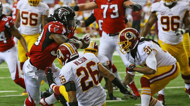 Falcons running back Steven Jackson knocks Redskins cornerback Josh Wilson to the ground on his way into the endzone for a 7-0 lead during 1st half action in a NFL football game on Sunday, Dec. 15, 2013, in Atlanta.