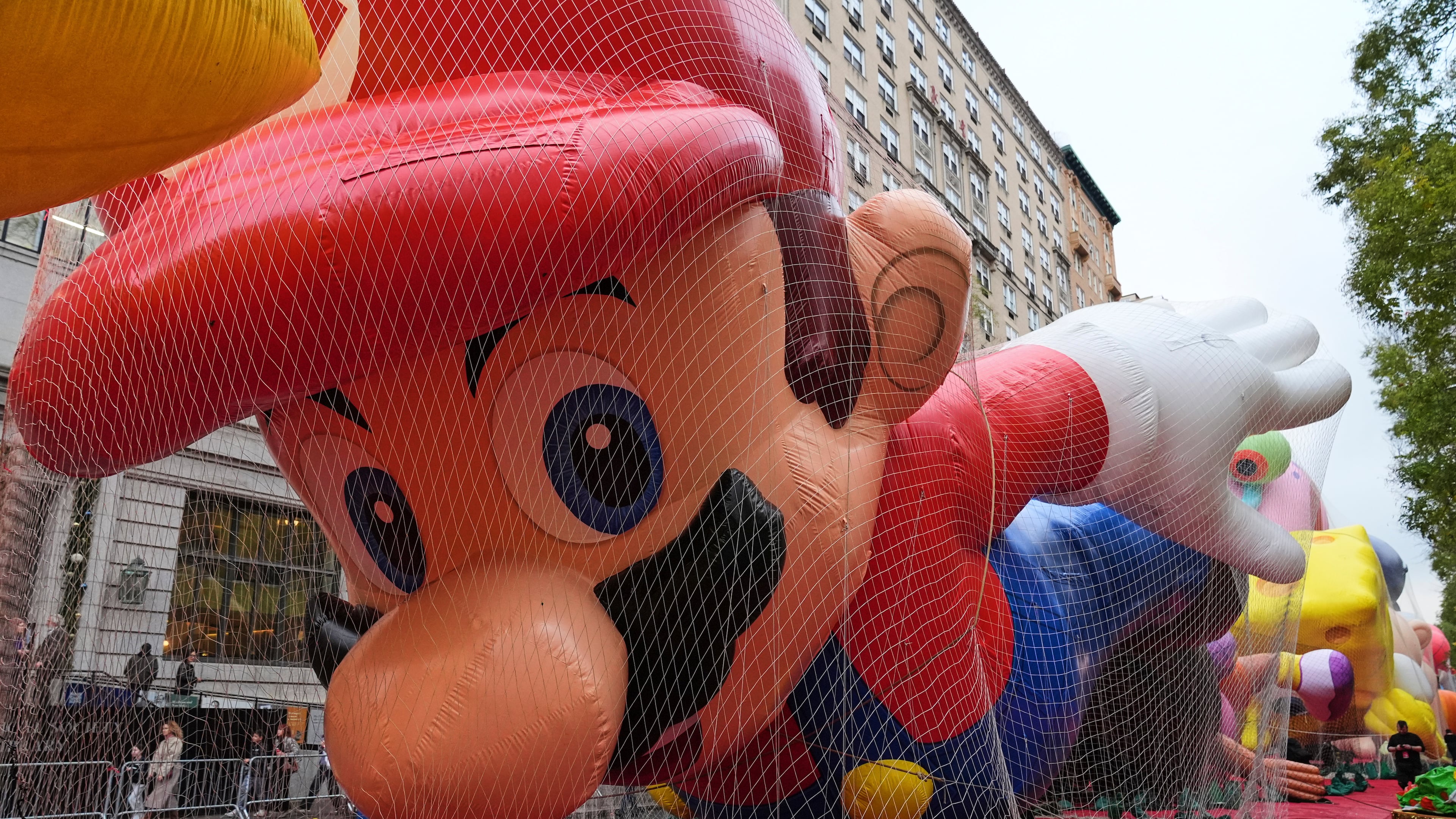People pass Mario balloon during inflation for the 99th Macy's Thanksgiving Day Parade Wednesday, Nov. 26, 2025, in New York. (AP Photo/Frank Franklin II)
