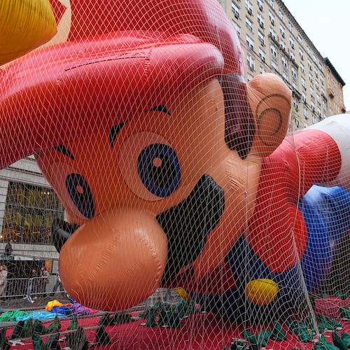 People pass Mario balloon during inflation for the 99th Macy's Thanksgiving Day Parade Wednesday, Nov. 26, 2025, in New York. (AP Photo/Frank Franklin II)