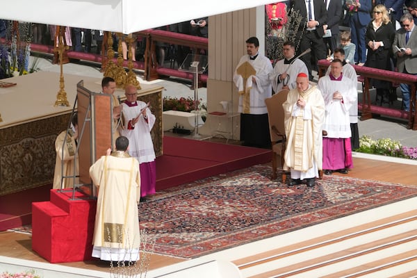 Cardinal Angelo Comastri, right, presides over the Easter mass in St. Peter's Square at the Vatican Sunday, April 20, 2025. (AP Photo/Gregorio Borgia)