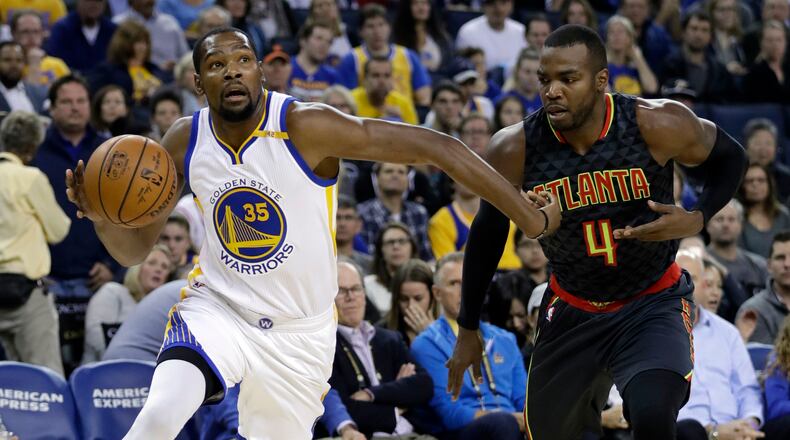 Golden State Warriors’ Kevin Durant (35) dribbles past Atlanta Hawks’ Paul Millsap (4) during the first half of an NBA basketball game, Monday, Nov. 28, 2016, in Oakland, Calif. (AP Photo/Marcio Jose Sanchez)