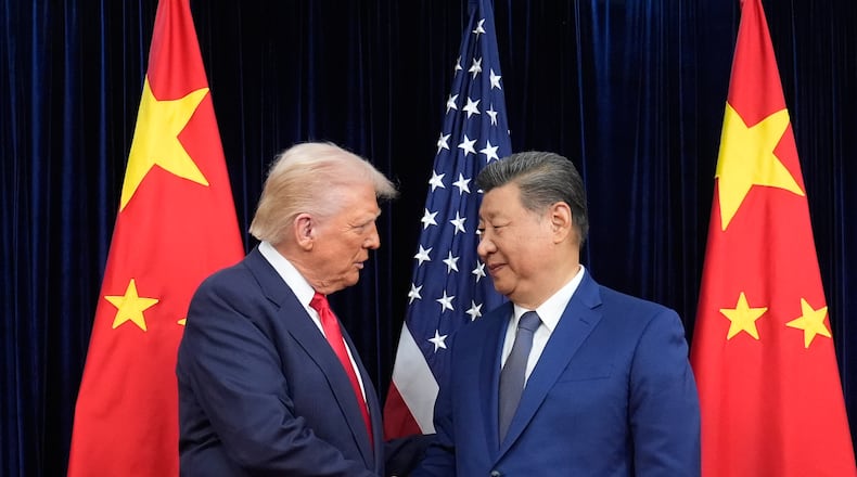 FILE - President Donald Trump, left, and Chinese President Xi Jinping, right, shake hands before their meeting at Gimhae International Airport in Busan, South Korea, Oct. 30, 2025. (AP Photo/Mark Schiefelbein, File)
