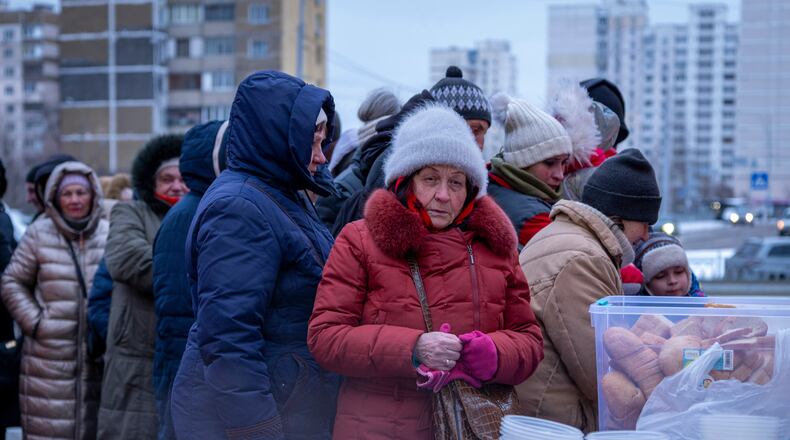 People who have no power at home following Russia's air attacks wait in line to receive free hot meals in a residential neighbourhood in Kyiv, Ukraine, Friday, Jan. 30, 2026. (AP Photo/Dan Bashakov)