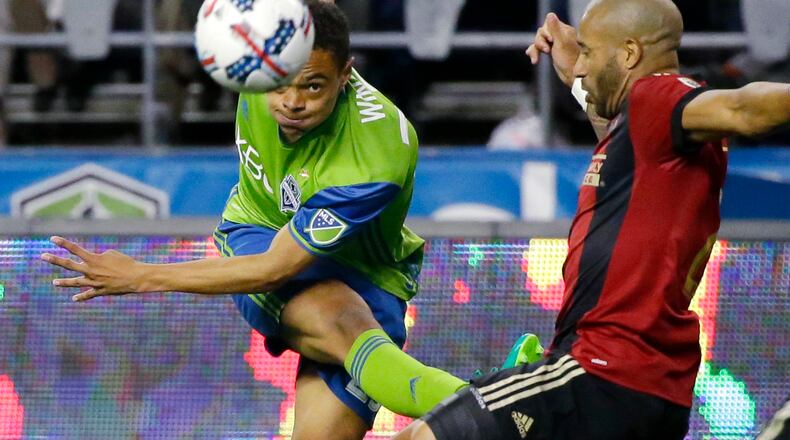 Seattle Sounders midfielder Henry Wingo, left, watches his pass under pressure from Atlanta United defender Tyrone Mears, right, in the second half of an MLS soccer match, Friday, March 31, 2017, in Seattle. The match ended in a 0-0 tie. (AP Photo/Ted S. Warren)