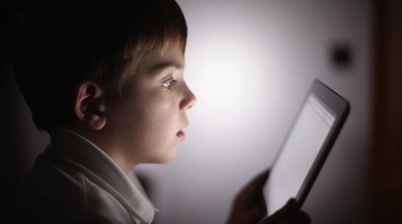 In this photograph illustration, a 10-year-old boy uses an Apple Ipad tablet computer. CHRISTOPHER FURLONG/GETTY IMAGES