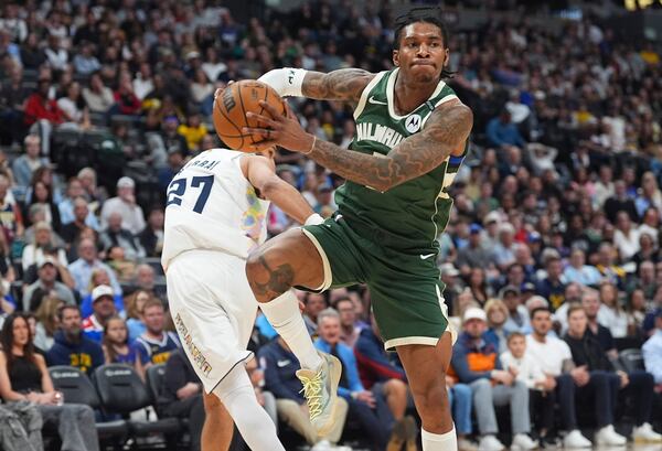 Milwaukee Bucks guard Kevin Porter Jr., front, drives to the basket past Denver Nuggets guard Jamal Murray in the first half of an NBA basketball game Wednesday, March 26, 2025, in Denver. (AP Photo/David Zalubowski)