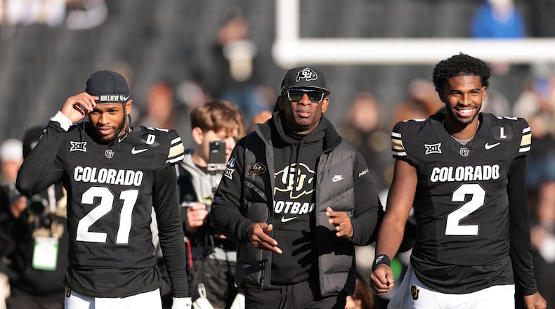 (L-R) Shilo Sanders (21), head coach Deion Sanders and Shedeur Sanders (2) of the Colorado Buffaloes walk the field during senior day celebrations prior to the game against the Oklahoma State Cowboys at Folsom Field on Nov. 29, 2024, in Boulder, Colorado. (Andrew Wevers / Getty Images / TNS)