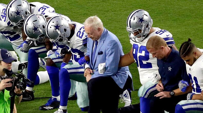 FILE - In this Monday, Sept. 25, 2017, file photo, the Dallas Cowboys, led by owner Jerry Jones, center, take a knee prior to the national anthem before an NFL football game against the Arizona Cardinals in Glendale, Ariz. What began more than a year ago with a lone NFL quarterback protesting police brutality against minorities by kneeling silently during the national anthem before games has grown into a roar with hundreds of players sitting, kneeling, locking arms or remaining in locker rooms, their reasons for demonstrating as varied as their methods. (AP Photo/Matt York, File)