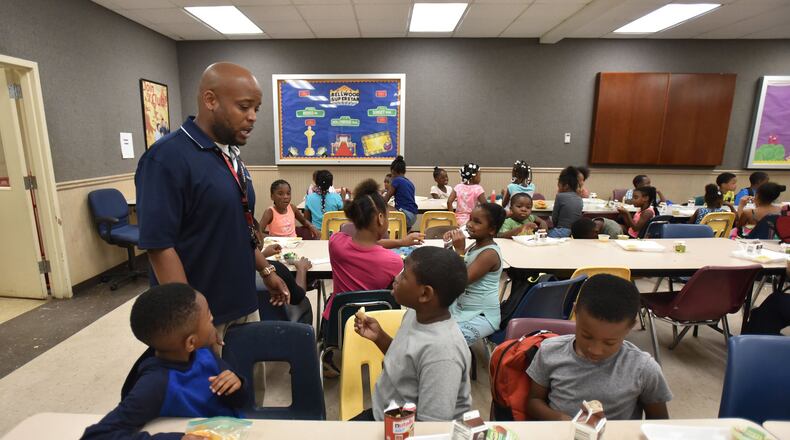 Javonn Lockhart, program director, assists children during the lunch hour at Salvation Army Boys and Girls Club Bellwood Unit in Atlanta on Wednesday. Thousands of children and teens in the United States rely on school meals. With school now out of session, the United States Department of Agriculture is organizing locations across the country to offer summer meals for these children. HYOSUB SHIN / HSHIN@AJC.COM