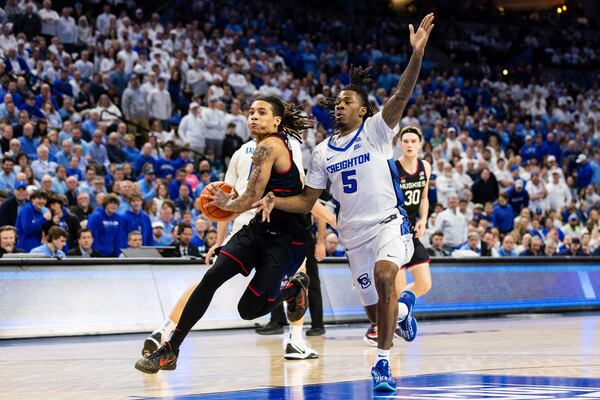 UConn guard Solo Ball, left, drives inside against Creighton guard Jamiya Neal (5) during the first half of an NCAA college basketball game, Tuesday, Feb. 11, 2025, in Omaha, Neb. (AP Photo/Bonnie Ryan)