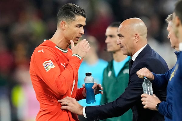 Portugal's Cristiano Ronaldo, left, talks with his coach Roberto Martinez during the Nations League final soccer match between Portugal and Spain at the Allianz Arena in Munich, Germany, Sunday, June 8, 2025. (AP Photo/Martin Meissner)
