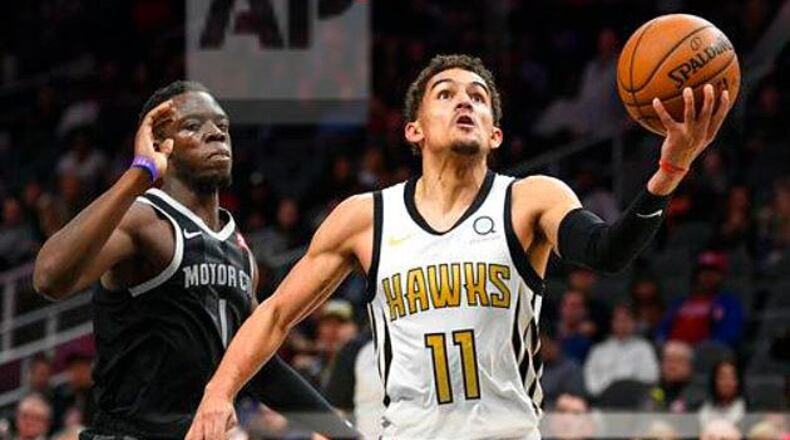 Hawks guard Trae Young drives to the basket while Reggie Jackson defends during Friday's game. (John Amis/AP)