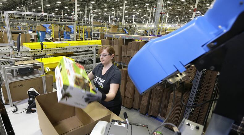 An Amazon worker places an item in a box for shipment during a media tour of a fulfillment center in Washington. (AP Photo/Ted S. Warren, File)