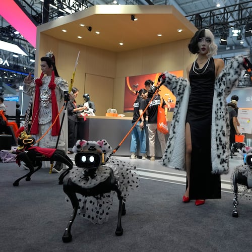 Models showing their robotic dogs with fancy dressing at a booth during the World Robot Conference at the Beiren Yichuang International Convention and Exhibition Centre in Beijing, Wednesday, Aug. 19, 2026. (AP Photo/Andy Wong)