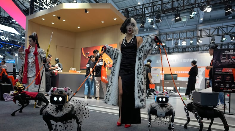 Models showing their robotic dogs with fancy dressing at a booth during the World Robot Conference at the Beiren Yichuang International Convention and Exhibition Centre in Beijing, Wednesday, Aug. 19, 2026. (AP Photo/Andy Wong)