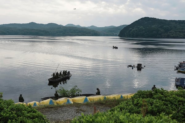 Members of Japan's Self-Defense Forces conduct a search for crew members at a reservoir in Inuyama, central Japan, Thursday, May 15, 2025, following the crash of an Air Self-Defense Force trainer jet Wednesday. (Koji Harada/Kyodo News via AP)