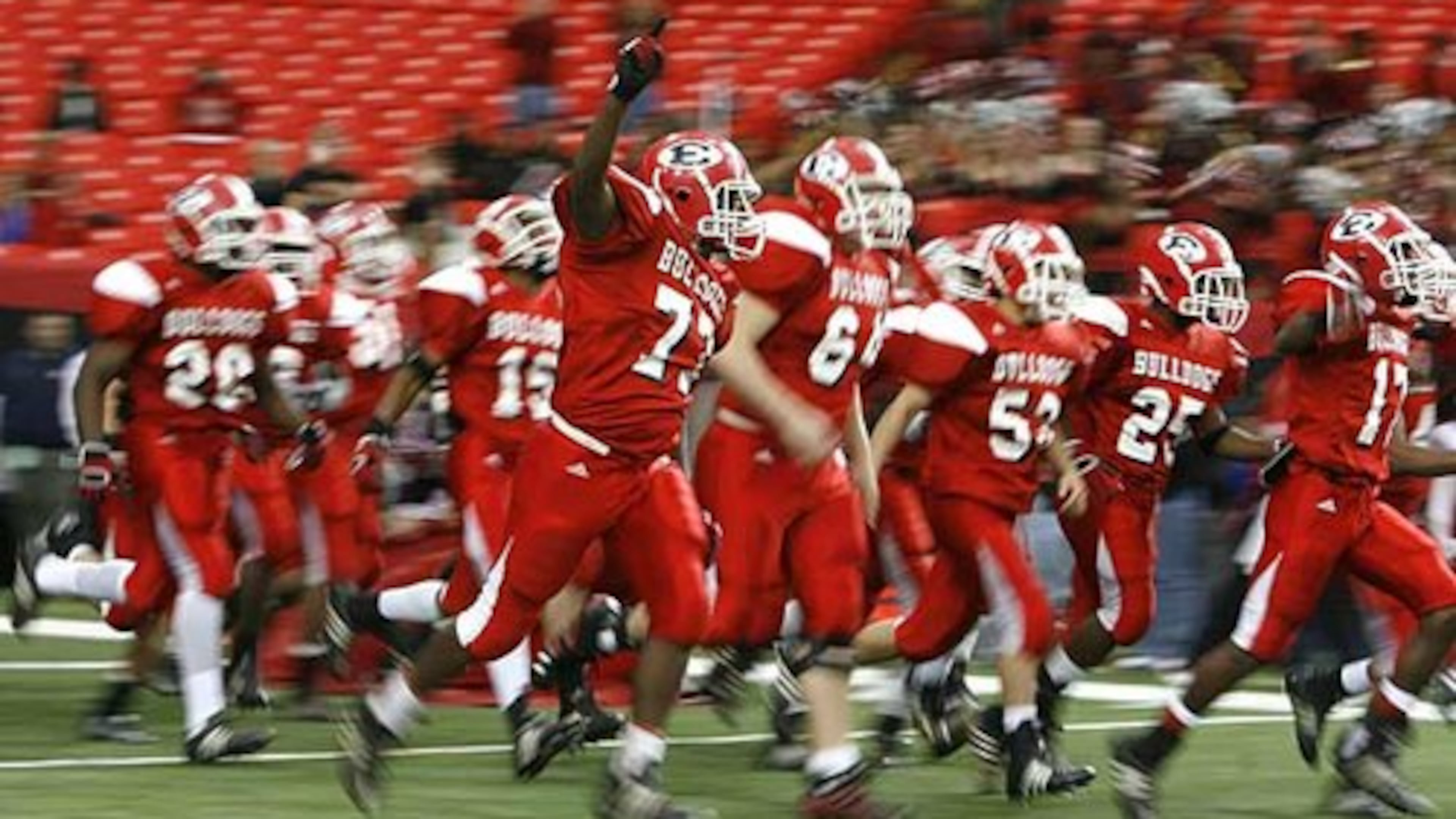 Emanuel County Institute run onto the field before their Class A state final against Wesleyan at the Georgia Dome. The school is among the smallest GHSA schools with a varsity football team. (Jason Getz/AJC)