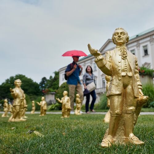 FILE - People walk by some of the 400 gold colored plastic Mozart sculptures by German artist Ottmar Hoerl from Nuremberg for the 270th birthday of composer Wolfgang Amadeus Mozart in Salzburg, Austria, Wednesday, July 15, 2026. (AP Photo/Matthias Schrader, File)