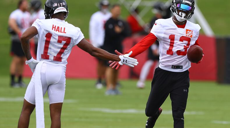 Wide receiver Reggie Davis gets five from Marvin Hall after catching a long pass on the first day of mandatory mini-camp on Tuesday, June 12, 2018, in Flowery Branch.  Curtis Compton/ccompton@ajc.com