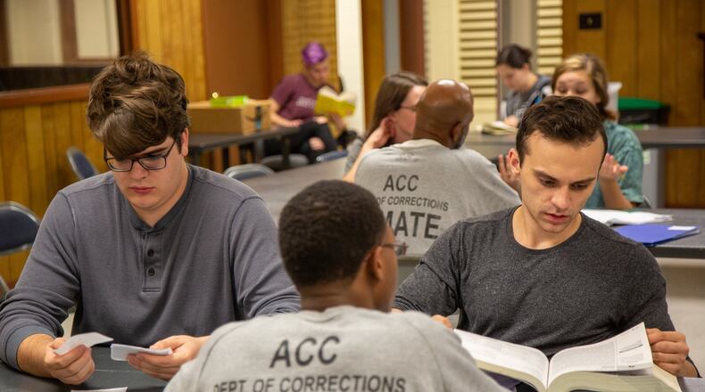 UGA students Ben Price (left) and Zachary Reynolds help a state prisoner during a GED class at the Athens-Clarke County Correctional Institution in Athens. UGA students Kavi Pandian of Tucker and Manasa Kadiyala of Johns Creek created the program in 2016. Contributed by Phil Skinner