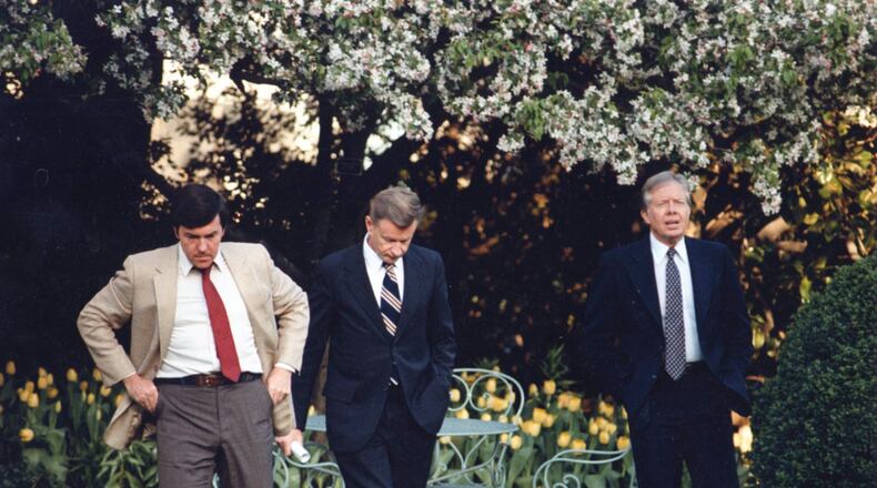 Hamilton Jordan (left) Zbigniew Brezinski (center) and President Jimmy Carter walk away from a patio following at meeting at the White House in the spring of 1980. (Cox Washington Bureau)