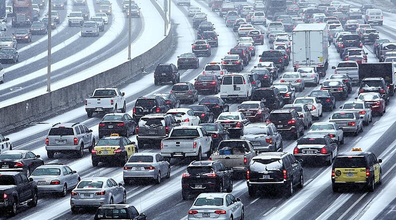 Traffic inches along the Connector as snow blankets the Metro on Tuesday afternoon January 28, 2014 as seen from the Pryor Street overpass.