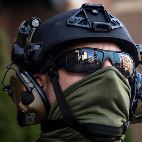 FILE - Federal immigration enforcement agents keep watch as they detain a man who took off running as they were walking on North Clark Street near West Superior Street in the River North neighborhood, Sept. 28, 2025, in Chicago. (Ashlee Rezin/Chicago Sun-Times via AP, File)