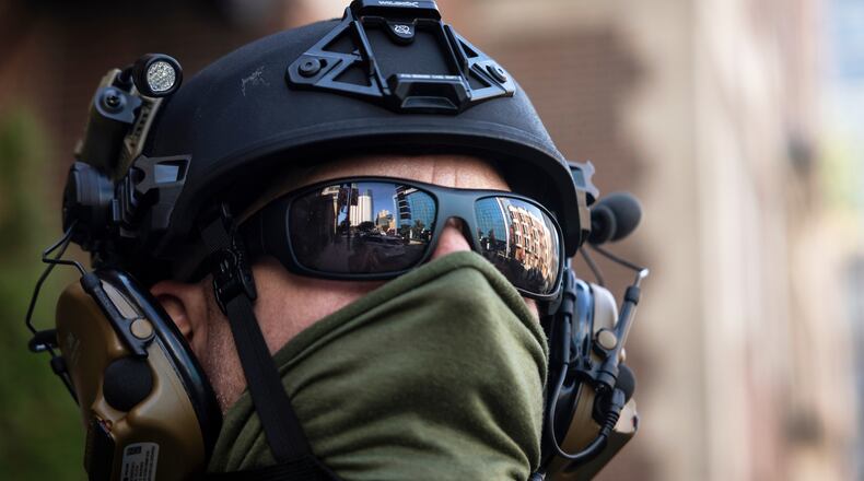 FILE - Federal immigration enforcement agents keep watch as they detain a man who took off running as they were walking on North Clark Street near West Superior Street in the River North neighborhood, Sept. 28, 2025, in Chicago. (Ashlee Rezin/Chicago Sun-Times via AP, File)