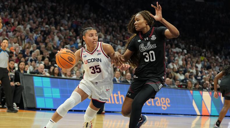 UConn guard Azzi Fudd (35) drives against South Carolina forward Maryam Dauda (30) during the first half of a woman's NCAA college basketball tournament semifinal game at the Final Four, Friday, April 3, 2026, in Phoenix. (AP Photo/Rick Scuteri)