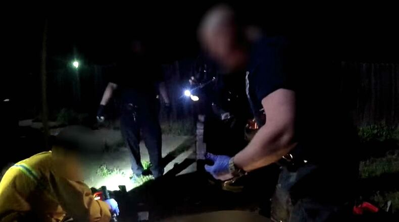 In a still image from a Sacramento police officer's body camera, city fire medics search Stephon Clark, off camera, for signs of life following his shooting death March 18, 2018. Clark, 23, was unarmed and carrying only a cellphone when he was shot eight times on his grandparents' back patio. His death has sparked protests in Sacramento and beyond, as well as calls for changes to the police department's use-of-force policy.