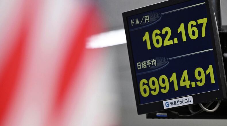 An electronic board shows Japan's benchmark Nikkei 225 index, bottom, and exchange rate of the Japanese yen against the U.S. dollar in Tokyo Tuesday, June 30, 2026. (Kenichiro Kojima/Kyodo News via AP)