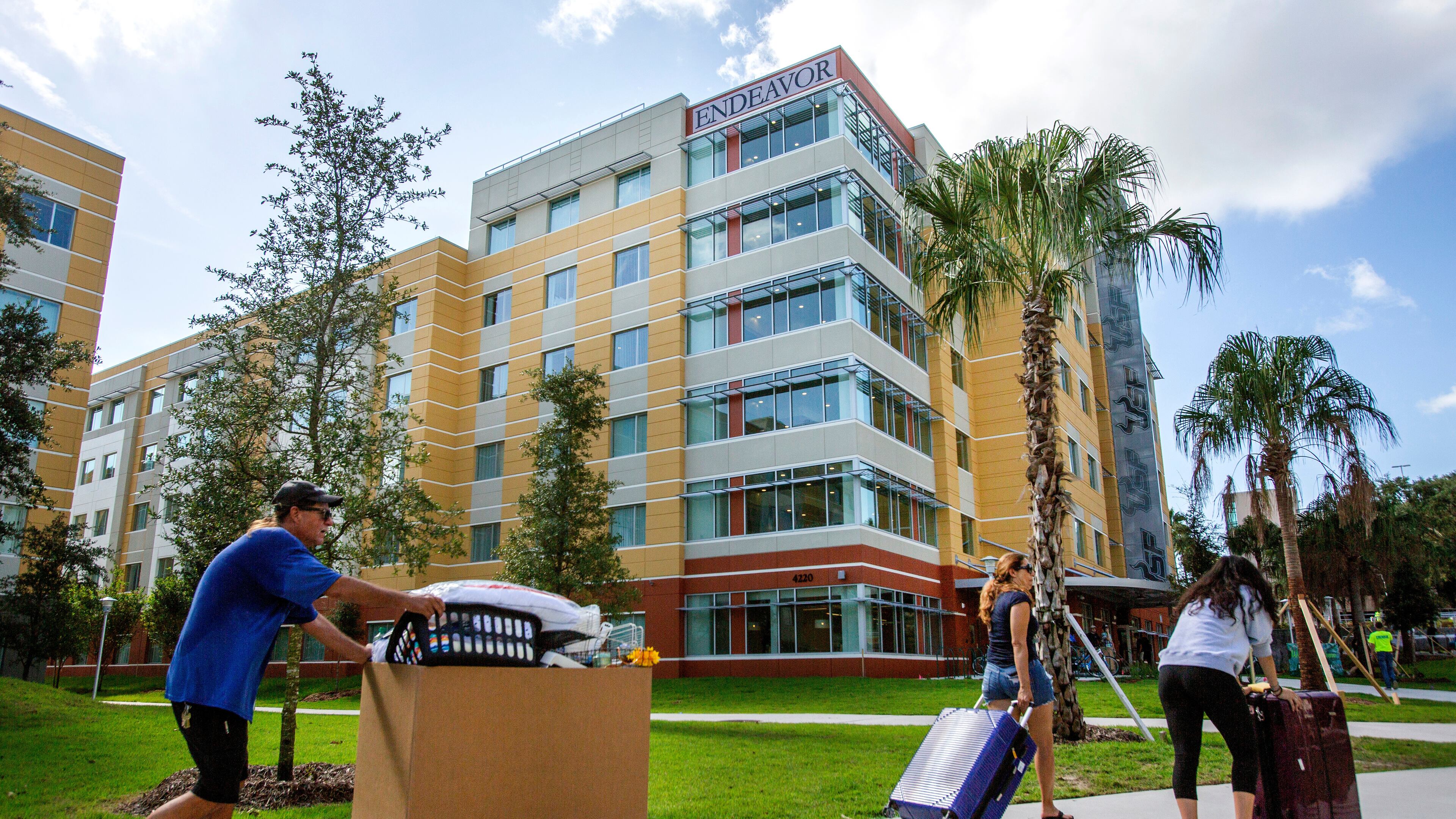 FILE - University of South Florida students walk with suitcases toward a dorm in Tampa on Aug. 16, 2018. (Bronte Wittpenn/Tampa Bay Times via AP)