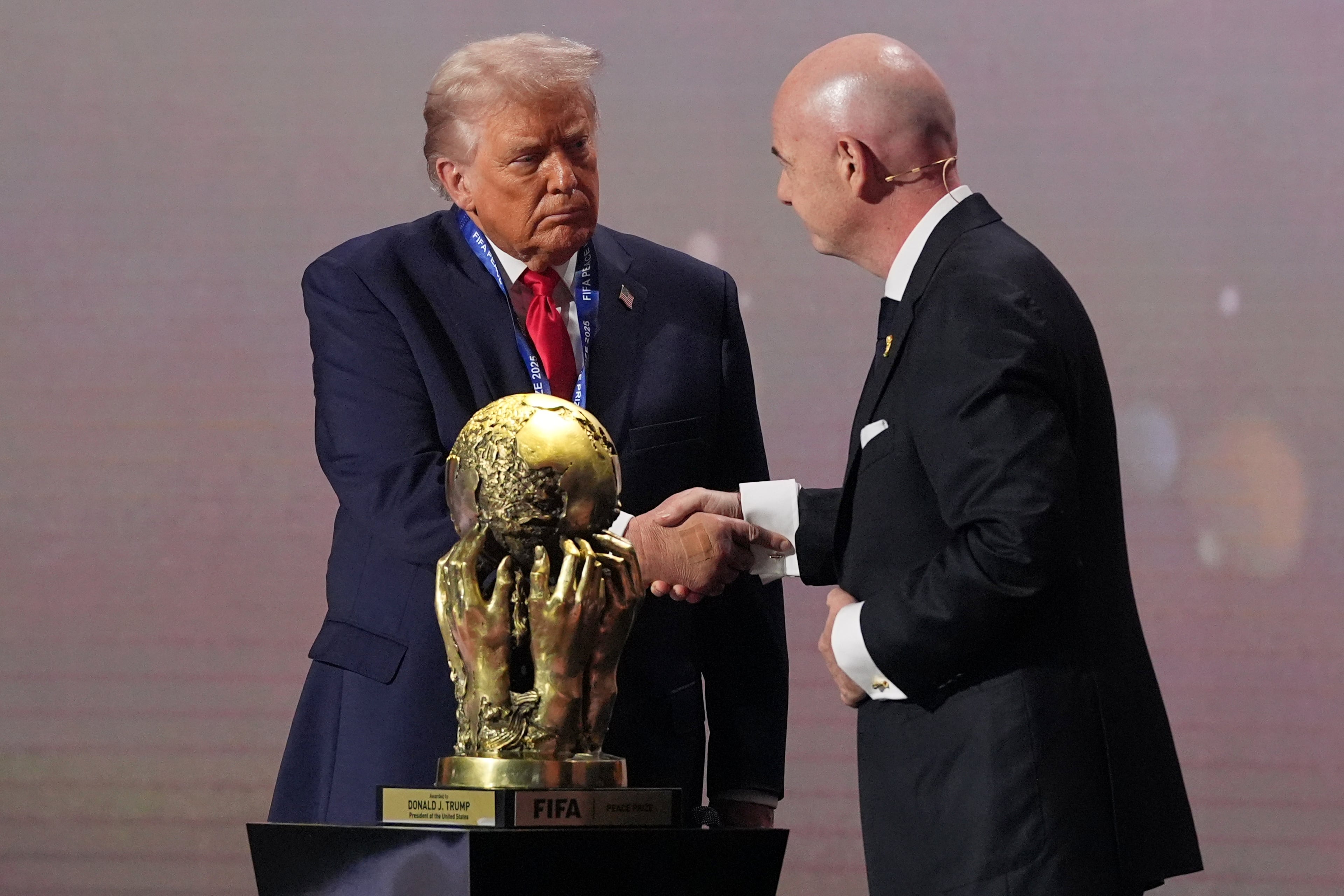 President Donald Trump receives the FIFA Peace Prize from FIFA President Gianni Infantino during the draw for the 2026 soccer World Cup at the Kennedy Center in Washington, Friday, Dec. 5, 2025. (AP Photo/Jacquelyn Martin)