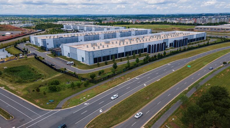 FILE - Cars drive past data centers, July 16, 2023, in Ashburn, Va. (AP Photo/Ted Shaffrey, File)