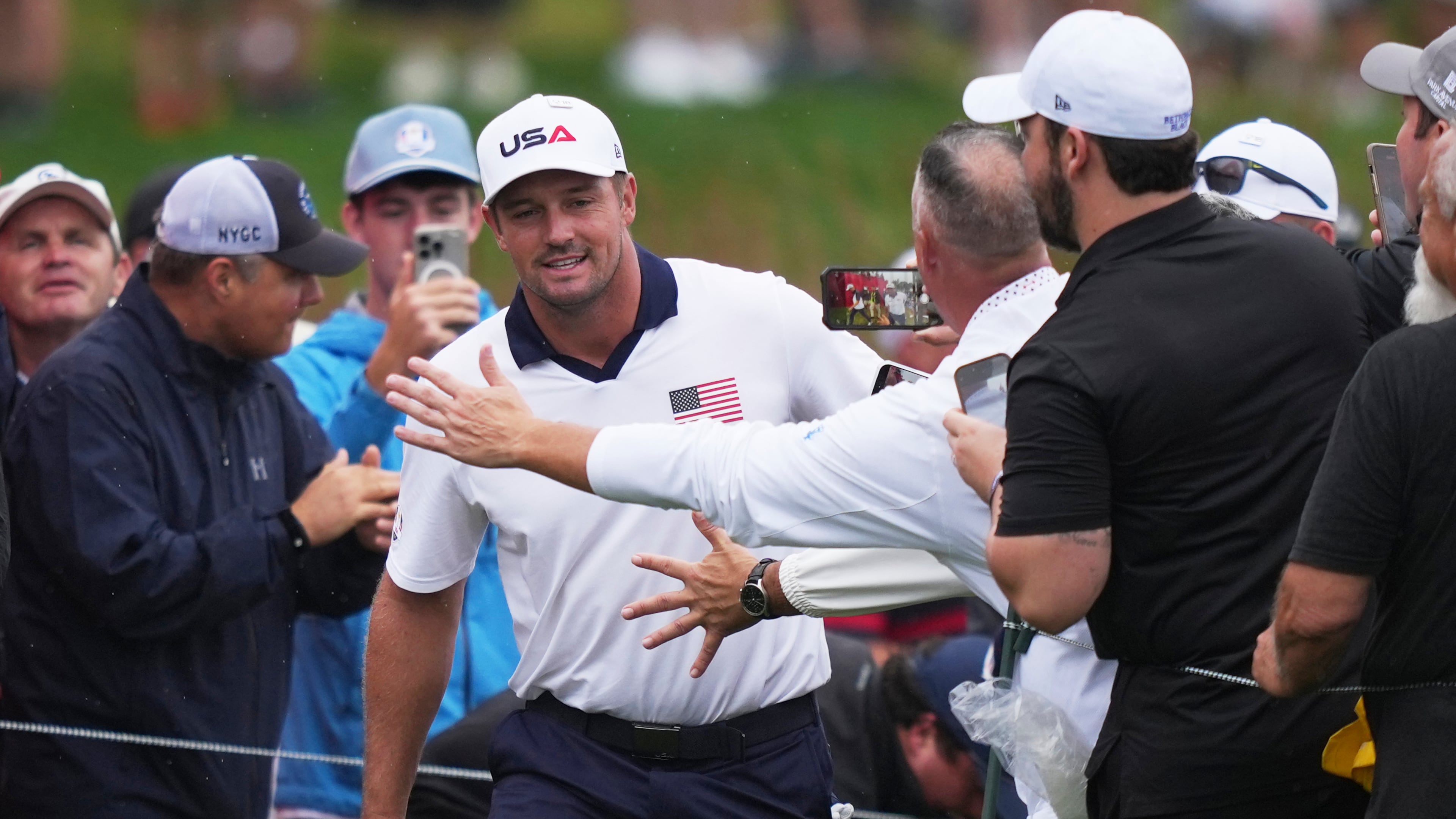Fans greets United States' Bryson DeChambeau on the 17th hole during a practice round at the Ryder Cup golf tournament, Thursday, Sept. 25, 2025, on the Bethpage Black golf course, in Farmingdale, N.Y. (AP Photo/Matt Slocum)