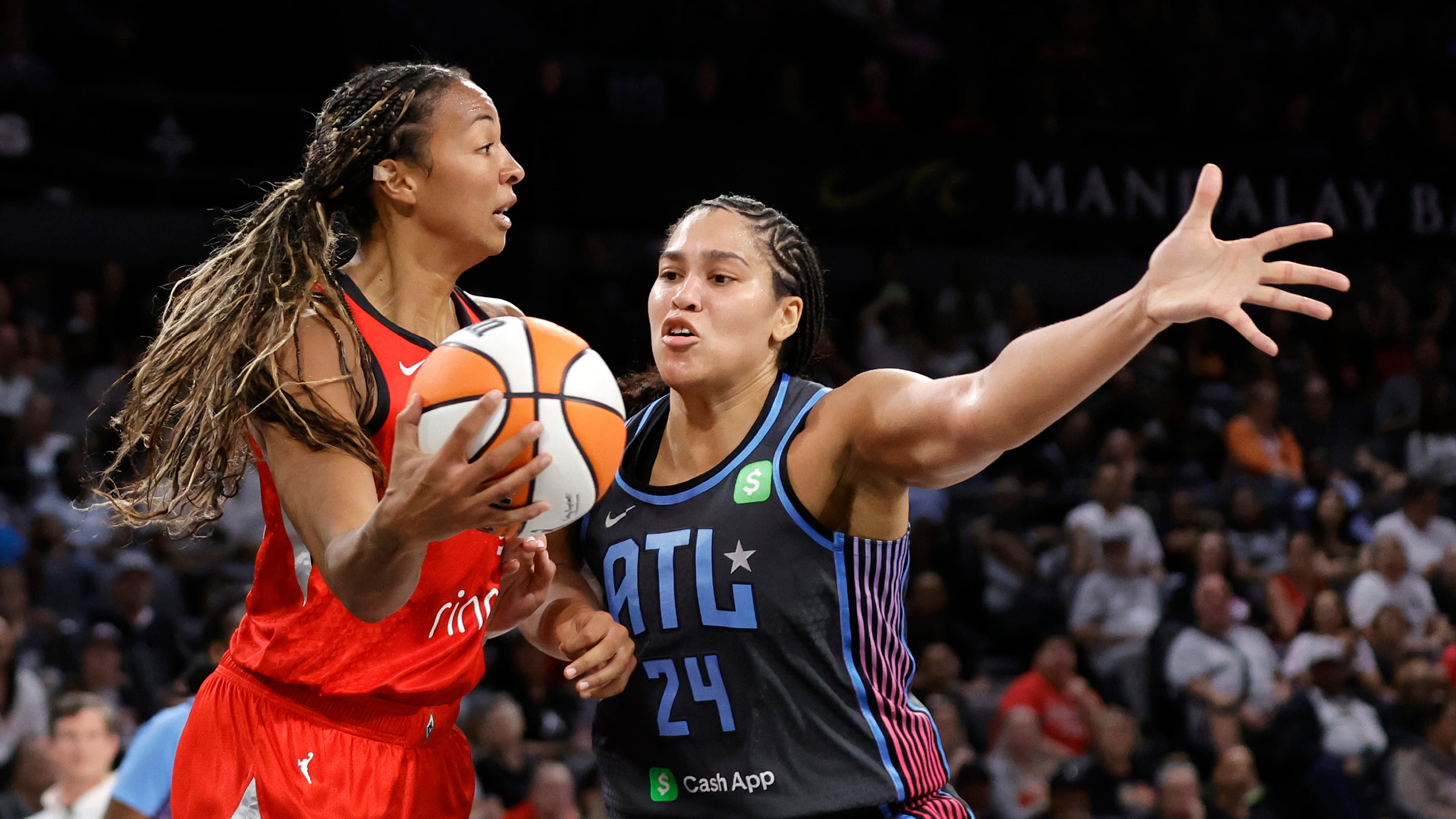 Las Vegas Aces center Kiah Stokes, left, looks to pass against Atlanta Dream forward Brionna Jones (24) during the first half of a WNBA basketball game Tuesday, July 22, 2025, in Las Vegas. (Steve Marcus/Las Vegas Sun via AP)