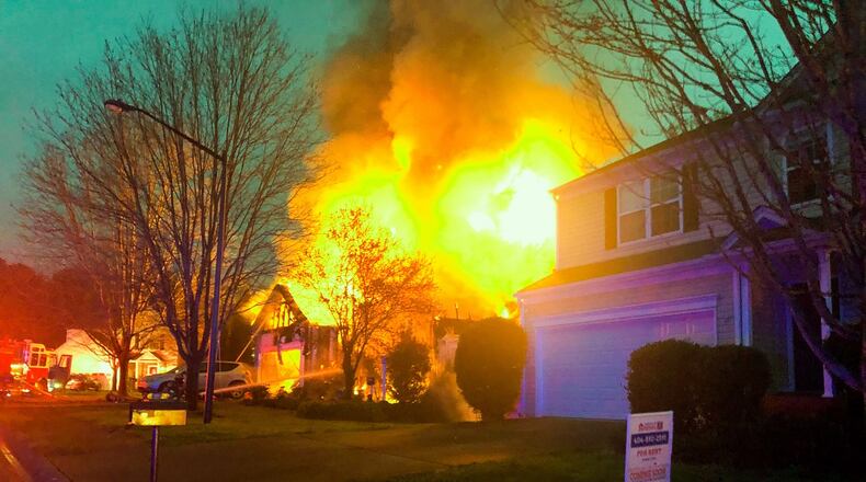 The flames were so intense they caused damage to a house next door.