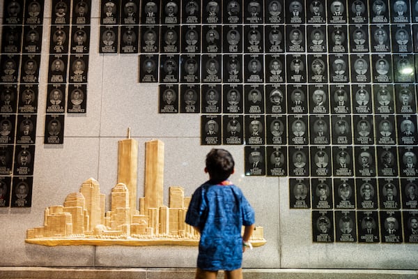 A young boy looks at the Brooklyn 9/11 Wall of Remembrance during the annual Candlelight Ceremony in Coney Island on the eve of the 25th anniversary of the Sept. 11 World Trade Center attacks. (Angelina Katsanis/AP)