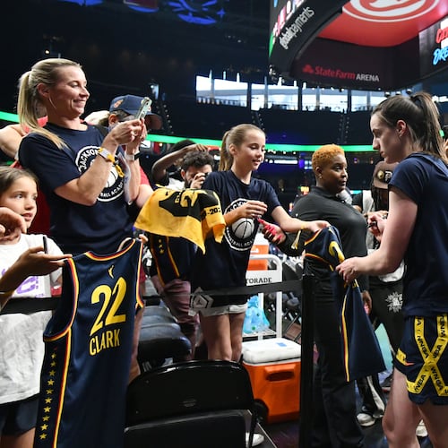 Indiana Fever guard Caitlin Clark (22) signs autographs for young fans before Atlanta Dream’s home opener against Indiana Fever at State Farm Arena, Thursday, May 22, 2025, in Atlanta. (Hyosub Shin / AJC)