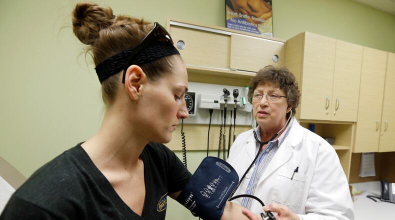 FILE - In this April 3, 2013 file photo, family Nurse Practitioner Ruth Wiley examines Elizabeth Knowles at a Walgreens Take Care Clinic in Indianapolis. (AP Photo/Darron Cummings, File)