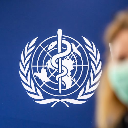 A person is wearing a protective face mask in front of the WHO logo, during the media regarding the epidemic of Ebola disease, during a press conference at the World Health Organization (WHO) headquarters in Geneva, Switzerland, Friday, May 22, 2026. (Martial Trezzini/Keystone via AP)
