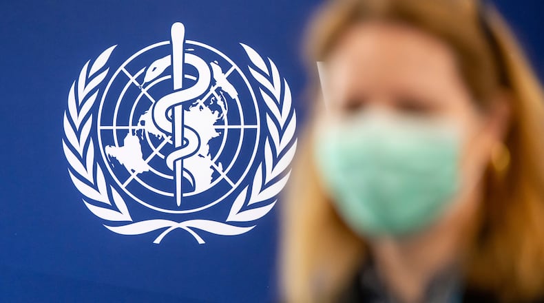 A person is wearing a protective face mask in front of the WHO logo, during the media regarding the epidemic of Ebola disease, during a press conference at the World Health Organization (WHO) headquarters in Geneva, Switzerland, Friday, May 22, 2026. (Martial Trezzini/Keystone via AP)
