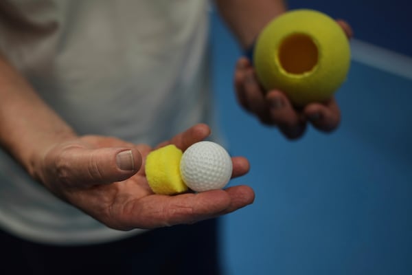 Tennis coach, Lee Neale, shows a ball used for visually impaired tennis during a training session in London, Wednesday, May 14, 2025. (AP Photo/Kin Cheung)