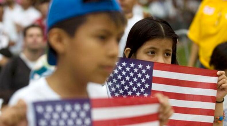 In 2010, Jason Rosales, 10, and his sister Jessica Rosales, 8, of Norcross, hold American flags during a march in support of immigration reform in downtown Atlanta.