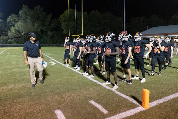 Glascock County head coach Chris Kelley, left, begins warm-ups with their players before the start of the second half of their game against Warren County at the Glascock County football stadium, Friday, Sept. 19, 2025, in Gibson, Ga. In GHSA’s smallest class, Class A Division II, Class A Glascock County is the second smallest school at 169, based on the most recent GHSA enrollment numbers used to classify schools. There are 31 players on their roster, and Friday, they played the fourth smallest team in Warren County, with 181 students and 33 players on their roster. (Jason Getz/AJC)