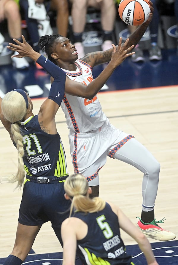 Connecticut Sun's Saniya Rivers (22) puts up a basket from under Dallas Wing's DiJonai Carrington (21) during a WNBA basketball game Tuesday, May 27, 2025, in Uncasville, Conn. (Sarah Gordon/The Day via AP)