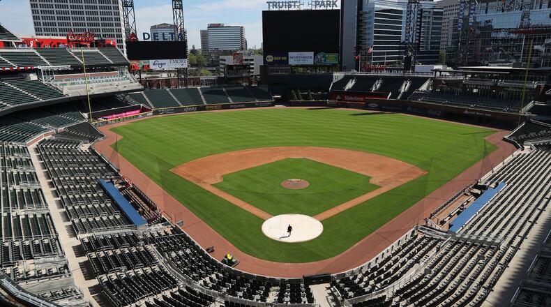 April 1, 2020 Atlanta: The stadium is eerily quiet except for Atlanta Braves field manager Tyler Lenz walking across the covered home plate while maintaining the quality of the field in the team���s newly renamed Truist Park on Wednesday, April 1, 2020, in Atlanta. The Braves were suppose to host their home opener this Friday, but the season���s start was postponed by Major League Baseball because of the coronavirus pandemic. A basic crew is keeping the quality of the field up to playing conditions while no one knows when, or even if, the 2020 season will start, or how long it might last. Curtis Compton ccompton@ajc.com